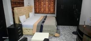 a bedroom with a bed and a dresser and a desk at Kembod hotel & suite in Ikeja