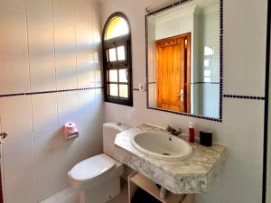 a bathroom with a sink and a toilet and a mirror at fuerte blue in Costa Calma +4 photos
