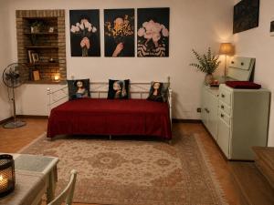 a bedroom with a red bed with two women on it at Residenza Il Castello Tre in CastellʼArquato