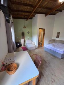 a room with a bed and a table and a couch at Villa Dona Jaca - Cabana 01 in Socorro