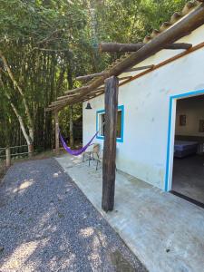 a house with a purple hammock outside of it at Villa Dona Jaca - Cabana 01 in Socorro
