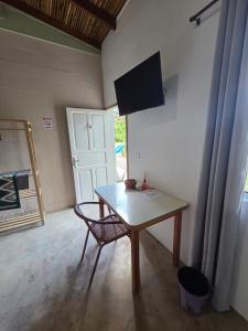 a table and a chair in a room with a door at Villa Dona Jaca - Cabana 01 in Socorro