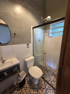 a bathroom with a toilet and a sink and a shower at Villa Dona Jaca - Cabana 01 in Socorro +6 photos