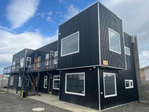 a black building with windows on the side of it at Ingloo in Puerto Natales
