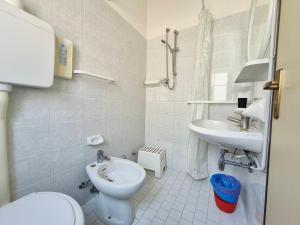 a white bathroom with a toilet and a sink at Hotel Luca in Valverde +62 photos