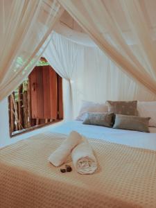 a bed with a towel and sandals on it at Casa 7 Caraíva No centrinho in Caraíva