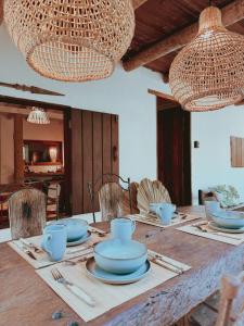 a wooden table with blue bowls and plates on it at Casa 7 Caraíva No centrinho in Caraíva