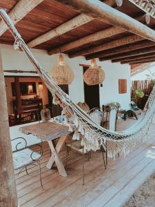 a hammock in a living room with a table and chairs at Casa 7 Caraíva No centrinho in Caraíva