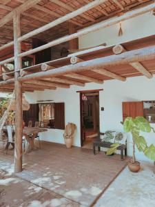 a living room with wooden ceilings and a table at Casa 7 Caraíva No centrinho in Caraíva