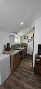a kitchen with wooden cabinets and a white refrigerator at Studio Mazalys-Entre Mer et Campagne in Crépon
