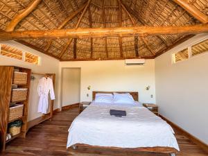 a bedroom with a bed and a wooden ceiling at Seúl Haus in El Sunzal