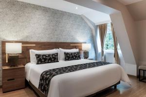 a bedroom with a large bed and a window at Hotel Portón de la Cabrera in Bogotá
