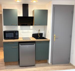 a kitchen with a sink and a microwave at Studio 2 neuf RDC hyper centre-ville in Bar-le-Duc