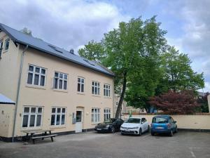 two cars parked in a parking lot next to a building at 4SEASONS - Golden Spring Suite in Aalborg