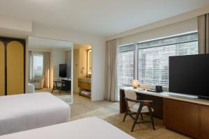 a hotel room with a bed and a desk with a television at JW Marriott Atlanta Downtown in Atlanta