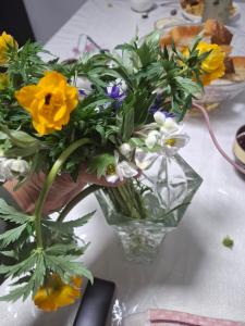 a vase filled with yellow and white flowers on a table at Cozy Stay Emir in Kazarman