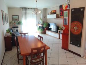a kitchen and dining room with a wooden table and a dining room at Vin's Apartment in Adro