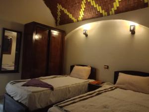 a bedroom with two beds and a mirror on the wall at Manzil Al-Wahati in Bawati +10 photos