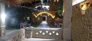 a building with an archway with tables and chairs at Manzil Al-Wahati in Bawati