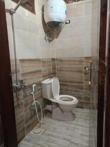 a bathroom with a toilet and a water tank at Manzil Al-Wahati in Bawati