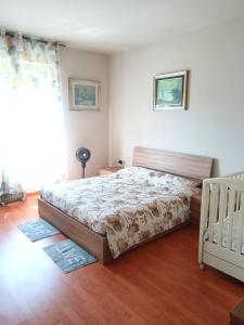 a bedroom with a bed and a crib in it at Vin's Apartment in Adro