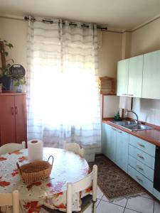 a kitchen with a table and a sink and a window at Vin's Apartment in Adro +13 photos