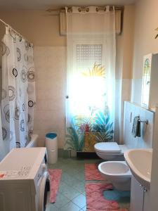 a bathroom with a sink and a toilet and a shower at Vin's Apartment in Adro