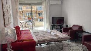 a living room with a couch and chairs and a tv at Appartamento Sole in Nice