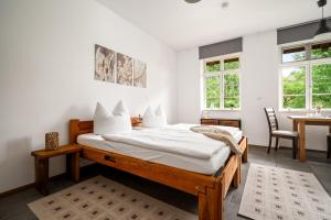 a bedroom with a bed and a table and windows at Roggenkammer in Rechlin