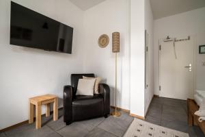 a living room with a chair and a flat screen tv at Roggenkammer in Rechlin