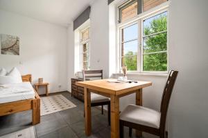 a room with a table and a bed and a bedroom at Roggenkammer in Rechlin