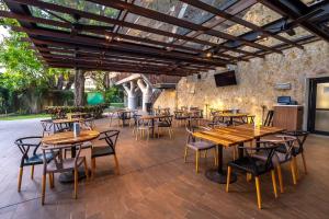 an outdoor patio with wooden tables and chairs at Courtyard by Marriott Tuxpan Veracruz in Tuxpan de Rodríguez Cano