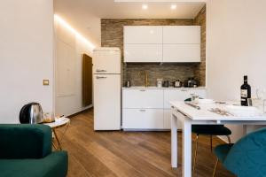 a kitchen with a white refrigerator and a table at Villa In Bed in Naples