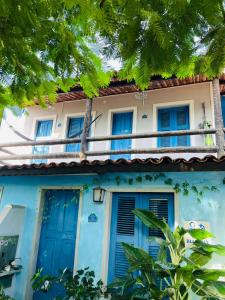 a blue house with blue doors and trees at Blue Day in Canoa Quebrada