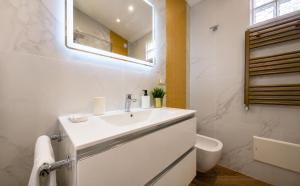 a white bathroom with a sink and a toilet at Villa In Bed in Naples