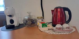 a table with a coffee maker and a tea kettle at Chez Néné in Châtillon