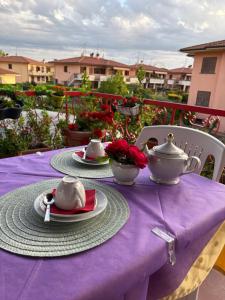 a table with a purple table cloth and tea sets on it at B&b ANNA in Bolsena