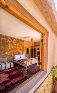a bedroom with two beds and a stone wall at Ouberge 'loassis house in Douar Azrou Melloul