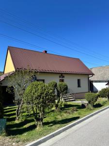 a house with a red roof on the side of the road at Domek u Krzyśka in Słopnice