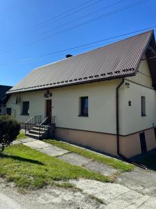 a white building with a metal roof at Domek u Krzyśka in Słopnice