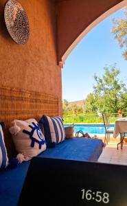 a room with a bed with pillows and a pool at Ouberge 'loassis house in Douar Azrou Melloul +11 photos