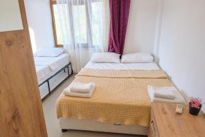 a small room with two beds and a table at Ekin Assos in Sokakagzi