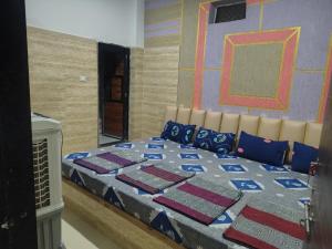 a bedroom with a large bed with blue pillows at Hotel Murlidhar in Chikāra