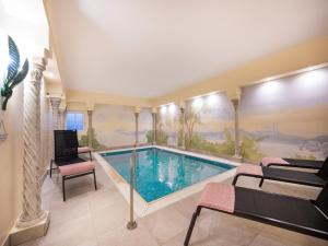 a swimming pool with chairs and a painting on the wall at Attraktives Studio mit Terrasse in Bad Birnbach in Bad Birnbach