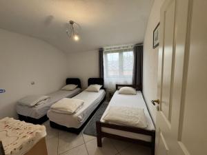 a room with three beds and a window at Apartmani Natura in Sanski most