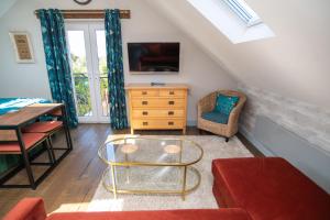 a living room with a table and a tv at Little Orchard House Self-catering Garden View apartment in Salcombe