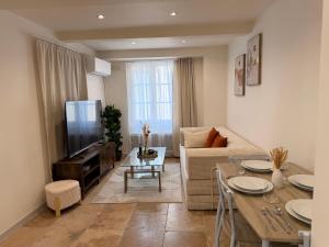 a living room with a couch and a tv at Le petit nid provençal in Sorgues