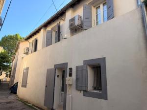 a white building with doors and windows on it at Le petit nid provençal in Sorgues