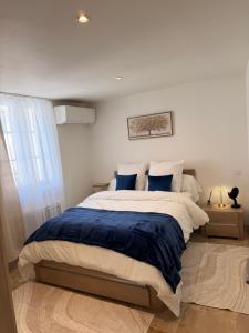 a bedroom with a large bed with blue pillows at Le petit nid provençal in Sorgues