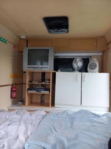 a bedroom with a bed and a tv and a tvicterictericterictericter at Ferienwohnwagen Rudolf in Coswig